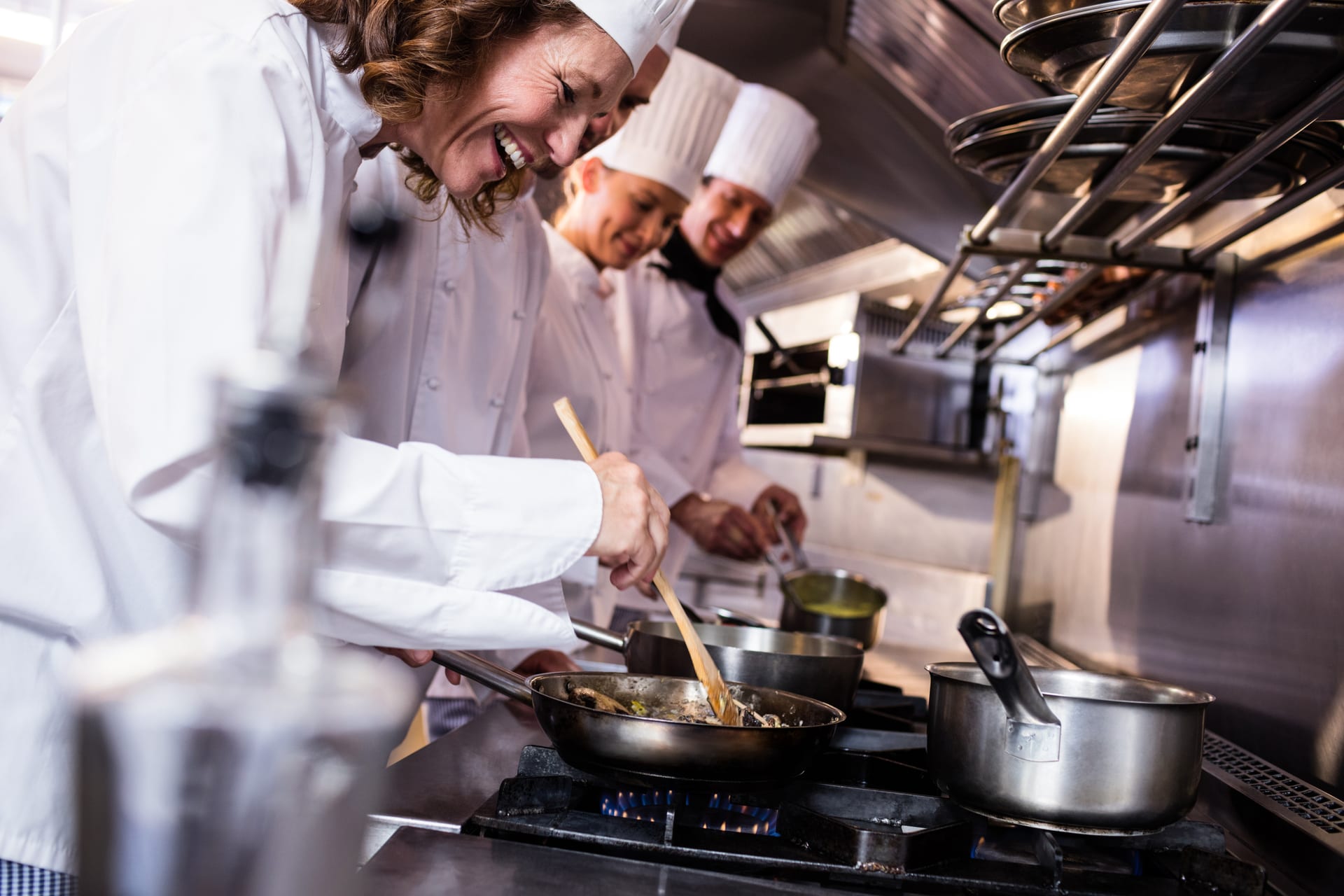 Kitchen team preparing meals at the cooking line in a large-scale kitchen
