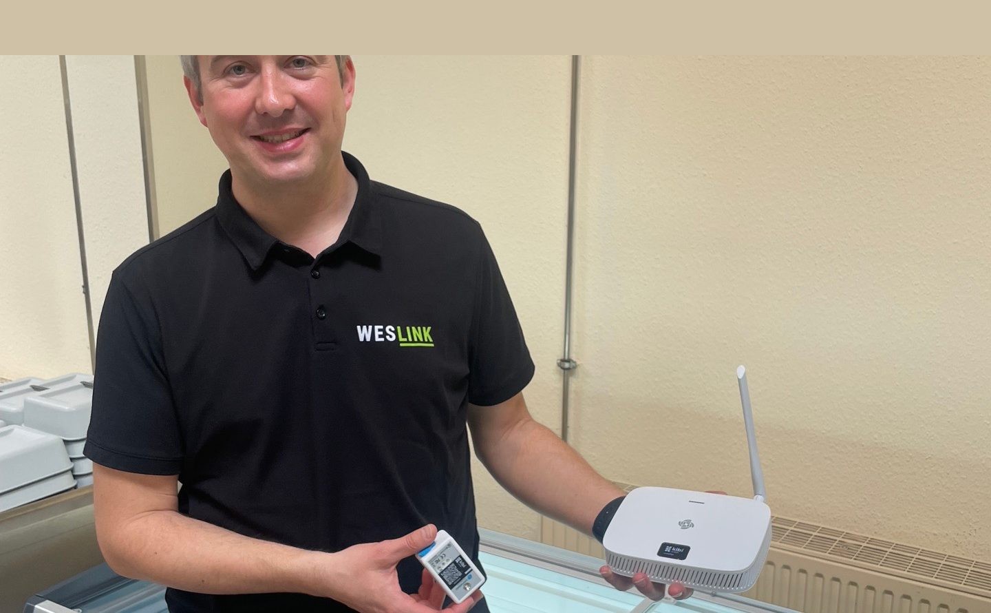 Weslink employees with Kibi Scada Gateway and wireless sensor on a freezer